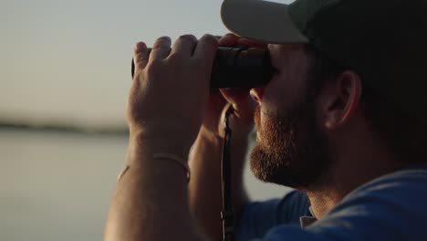 man searching for wild african animals on safari with a pair of binoculars