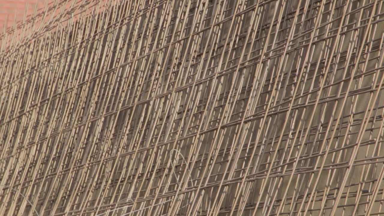 팬은 새 주택 건설 현장 바닥에 있는 강철 프레임을 닫습니다.