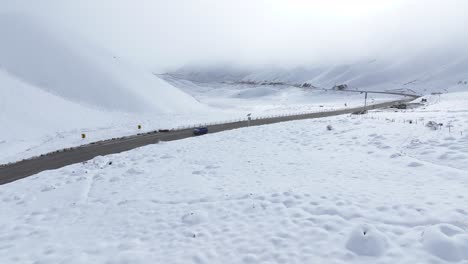 Vista-Aérea-De-La-Carretera-Cubierta-De-Nieve-Sobre-La-Cabeza-Del-Viajero.