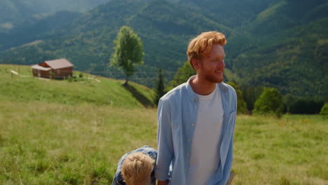 Happy-father-leading-son-by-hand-walking-hill-closeup.-Man-ruffling-boy-hair.