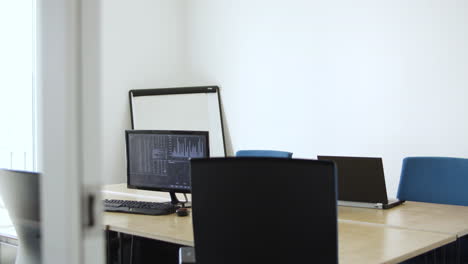 empty office space with computer, desk and chairs