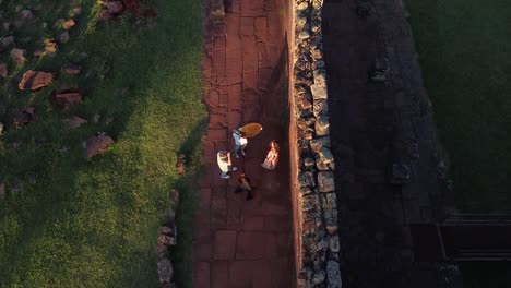 Aerial-view-of-model-and-photographer-taking-pictures-at-historic-ruins-in-south-america