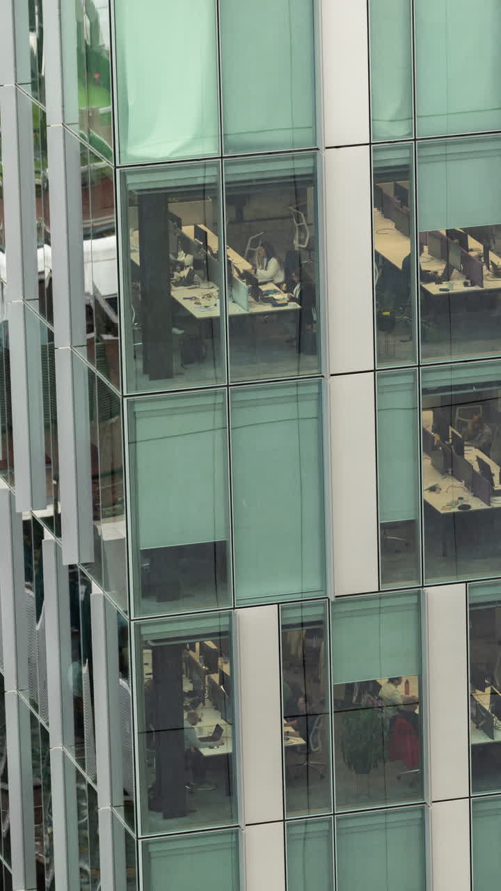 primer plano de la luz que pasa por encima de las ventanas de los bloques de oficinas de rascacielos en londres en vetical