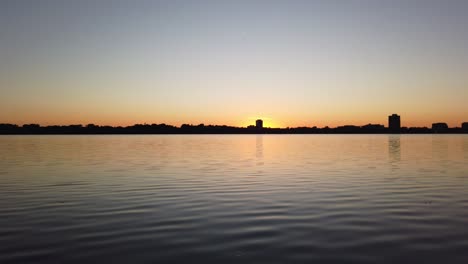 sun setting on the horizon seen from a lake