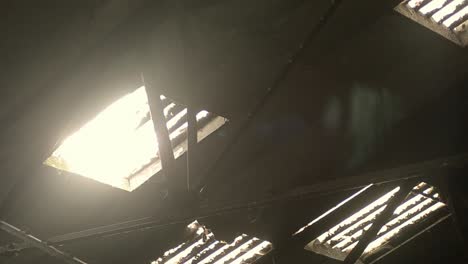 sun shines through rafter roof windows in derelict building