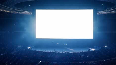 spectators are watching a bright, blank screen in a large arena, creating an atmosphere of anticipation and excitement