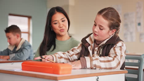 teacher assisting student in classroom