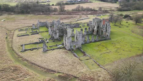 Ruinas-Del-Priorato-Del-Castillo-En-Medio-De-Campos-Verdes-En-Un-Día-Nublado,-Vista-Aérea