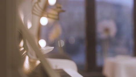 close up of curly woman sitting and playing piano