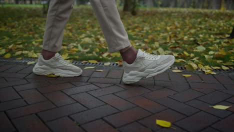 man feet walking in city park