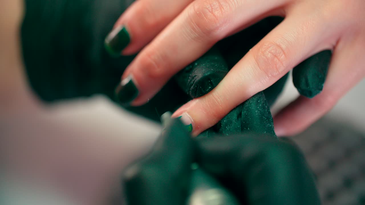 un manicurista muele las uñas con una máquina de manicura