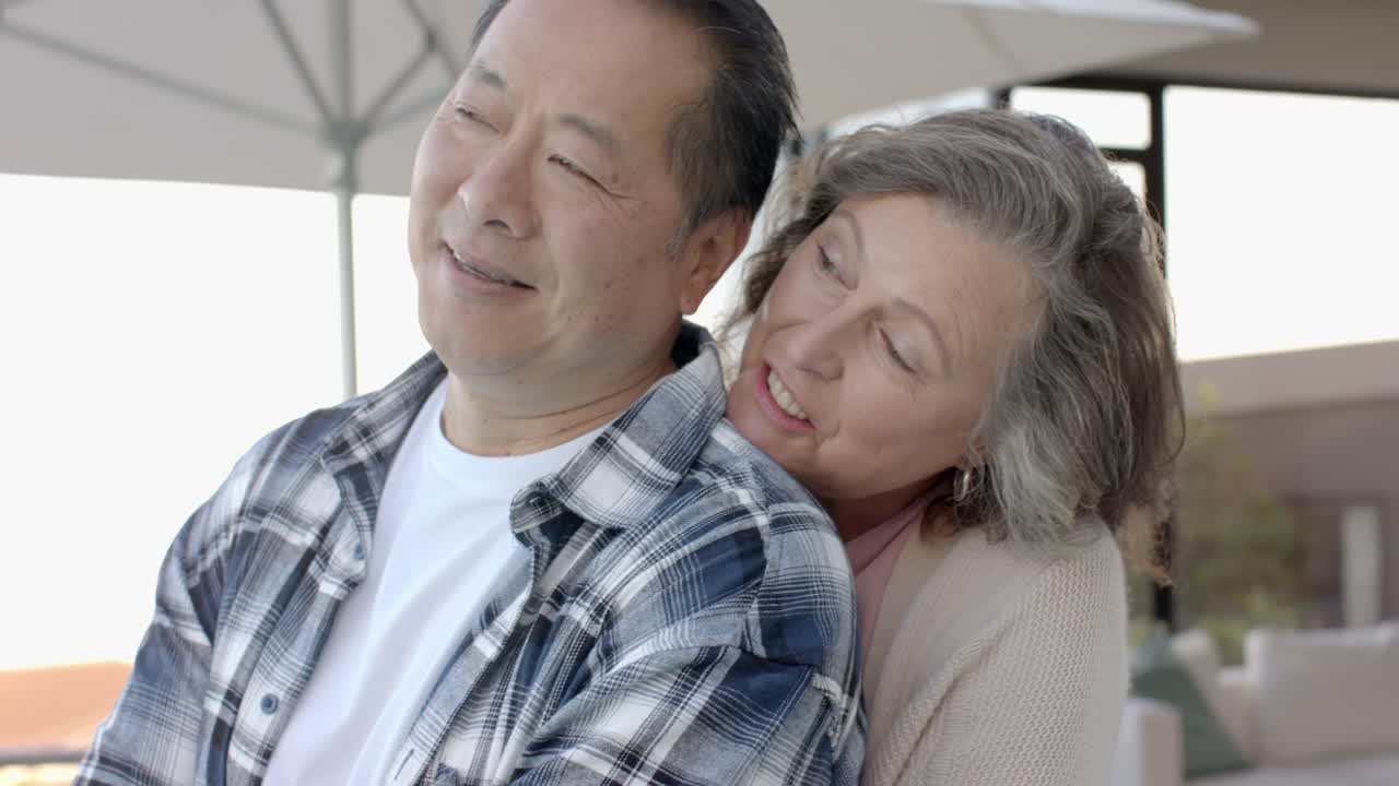 Embracing and smiling, senior couple enjoying vacation together outdoors