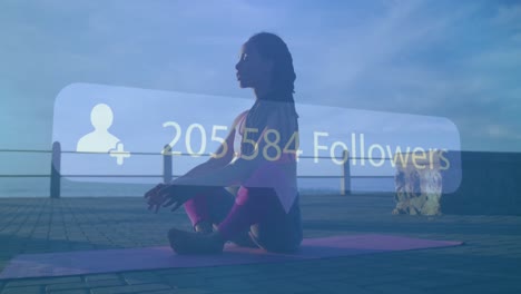 Animation-of-rising-number-of-followers-over-woman-meditating-on-promenade-by-the-sea