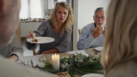 caucasian family sitting around table and spending christmas together.