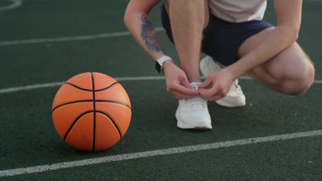 man tying shoes on basketball court