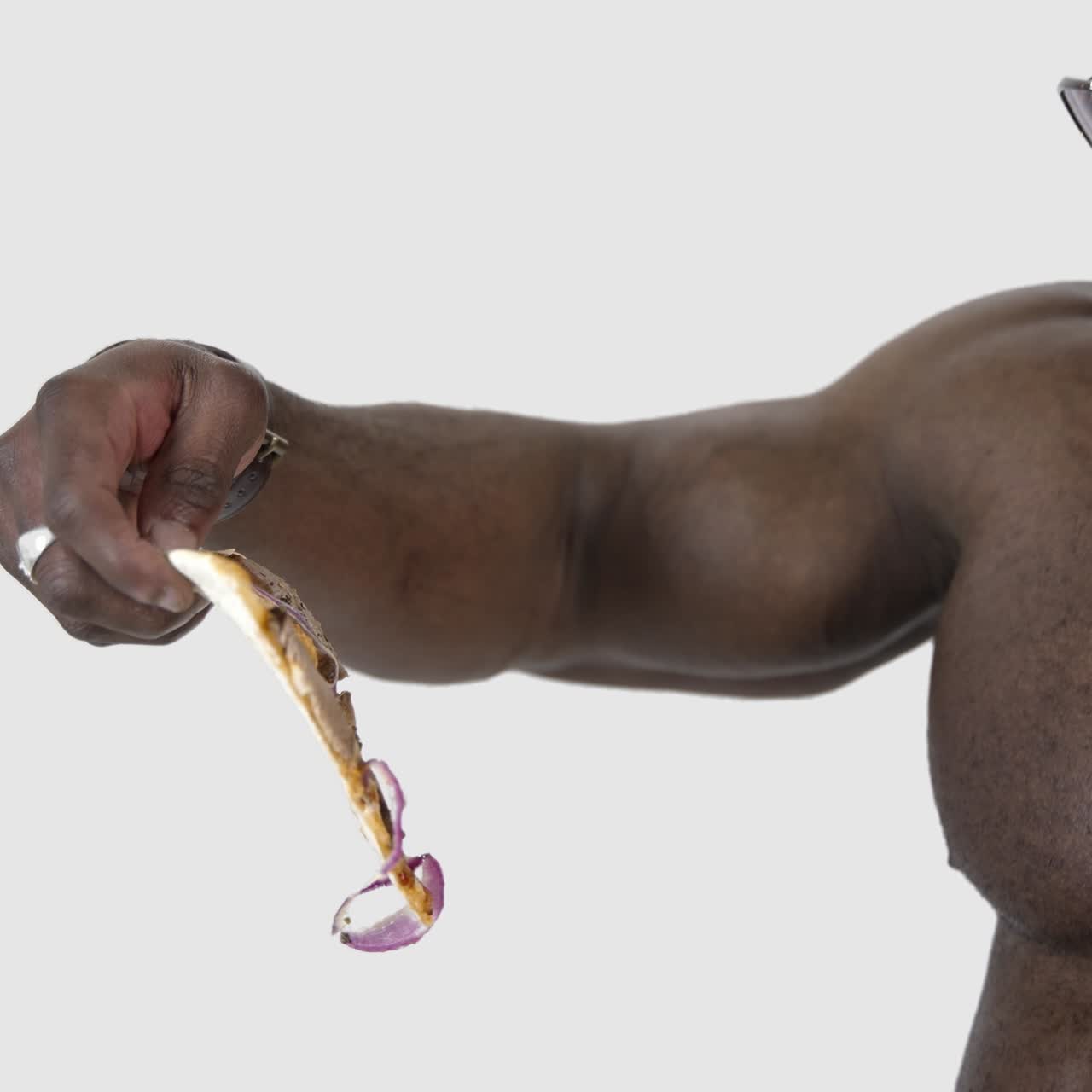 Delicious pizza in black man's hands. African man holds a box with delivered pizza and trying to eat some slice. Unhealthy food. Close-up. Slow motion