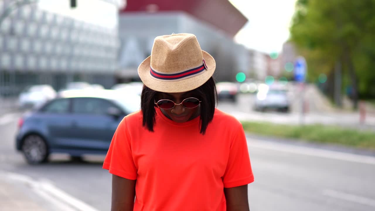 Woman with hat and sunglasses on city street