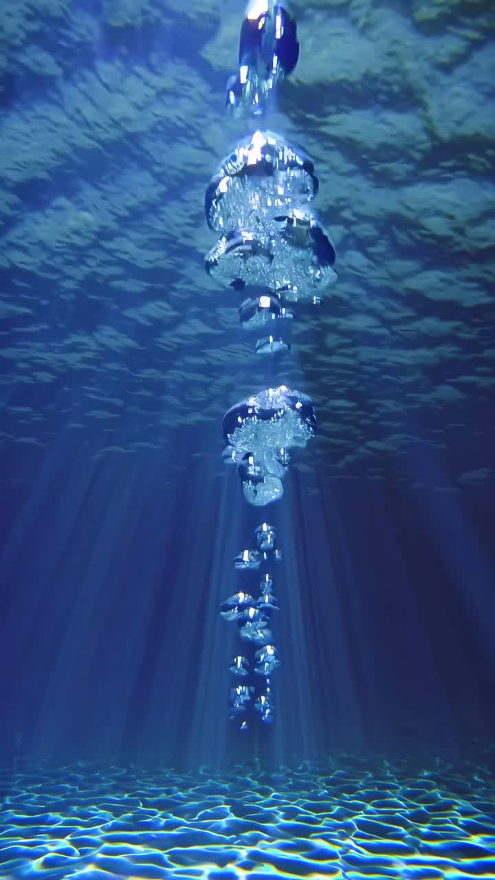 Video subacqueo che riprende bolle che salgono verso la superficie, visto dal basso.