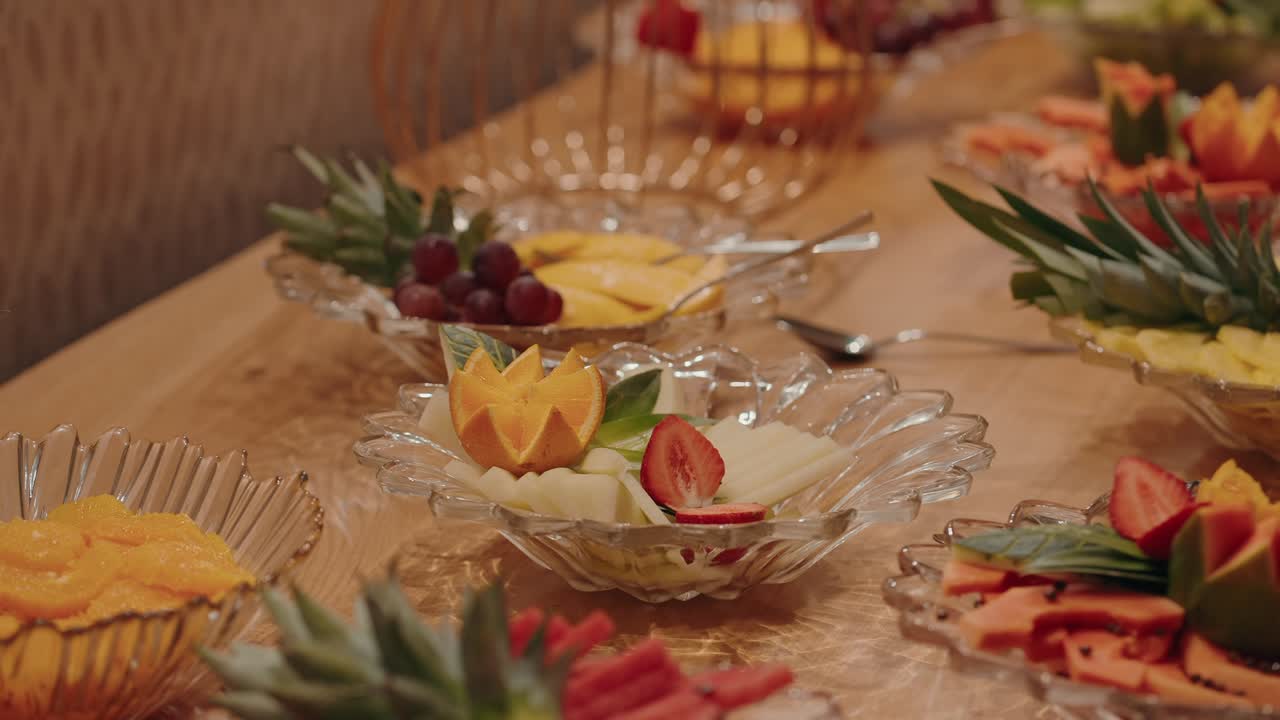 vibrant sliced fruit served on glass trays at festive indoor buffet