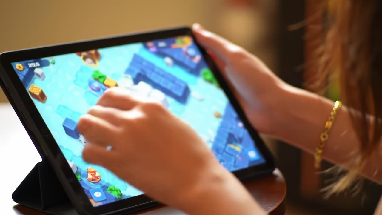 Engaging in Interactive Gameplay: A Close-Up of Hands on a Tablet Screen While Navigating Through a Colorful Gaming Environment Filled with Challenges and Fun