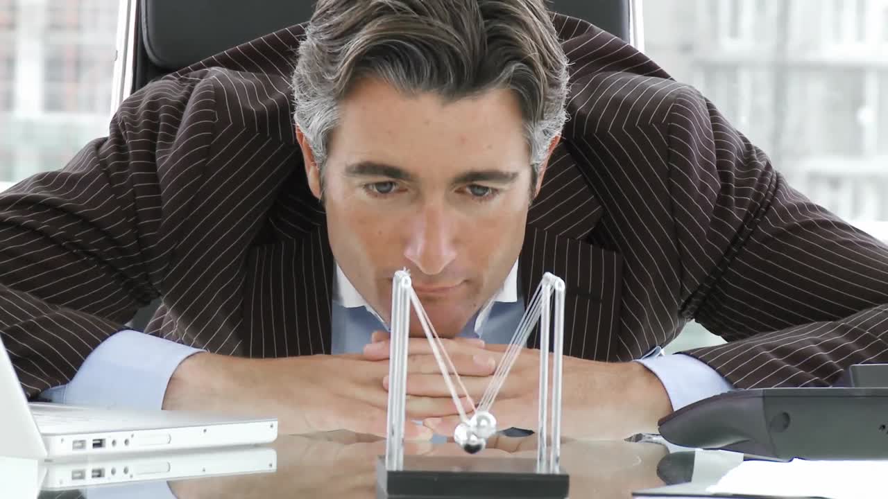 бизнесмен смотрит на кинетические шары