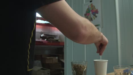 man measures coffee beans to make the perfect cup, slow motion medium shot