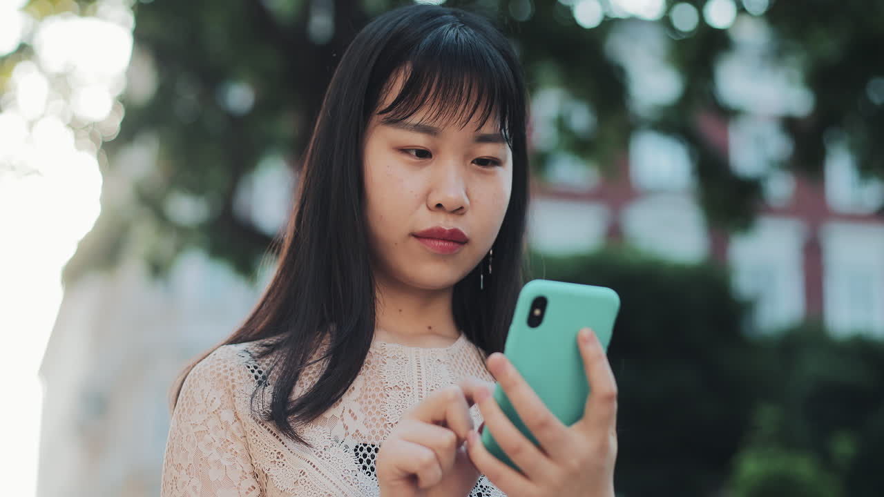 Young Asian woman using smartphone in the city