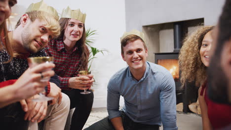 group of friends celebrating with champagne and talking after enjoying christmas dinner at home
