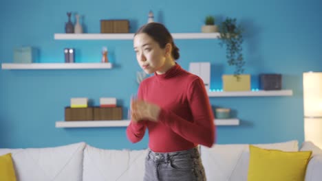 asian woman walking around the living room worried.