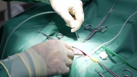 Surgeons in green scrubs work meticulously in a bright operating room, focusing on a complex procedure while using various surgical tools.