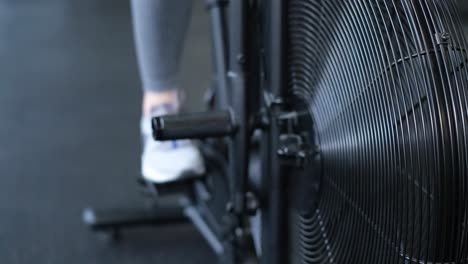 Active Woman Spinning Air Bike in Gym Brunette Female Training on Air Bike in Slow Motion F Active Woman Spinning Air Bike in Gym Brunette Female Training on Air Bike in Slow Motion Fitness Girl Working in Gym