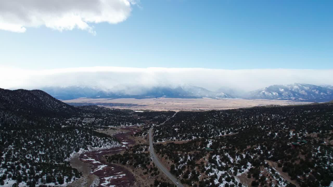 눈이 있는 록키 산맥의 외딴 고속도로의 높은 고도 무인 항공기 보기