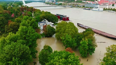 aerial view of rising floodwaters near the snp bridge in bratislava, with submerged riverbanks and floating structures. the iconic bratislava castle is visible in the background. (4k)