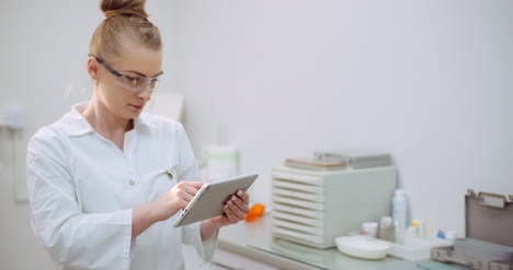 female doctor using digital tablet at dental clinic