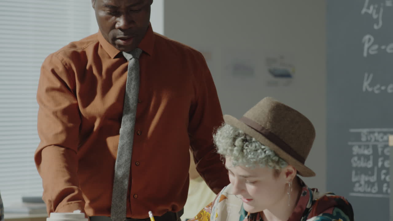 An instructor assists a student in a classroom setting