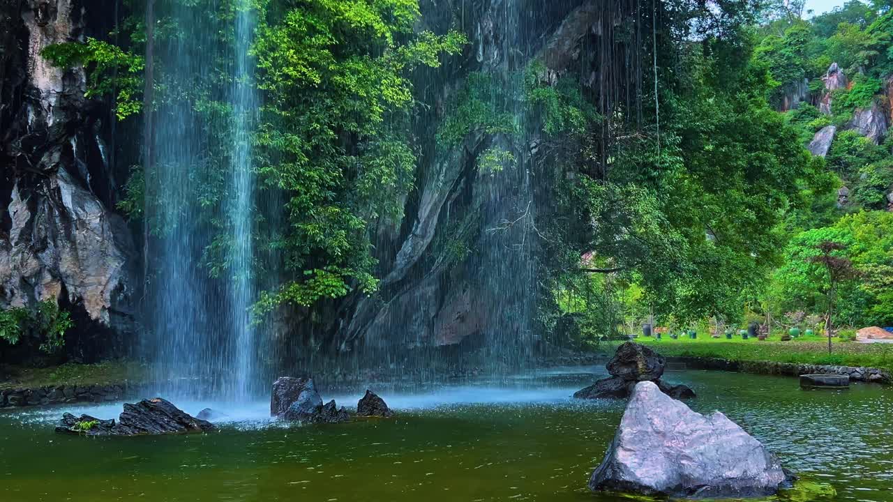 말레이시아 페라크 주 이포에 있는 구간 랭 레크리에이션 파크에 있는 호수에 떨어지는 인공 폭포