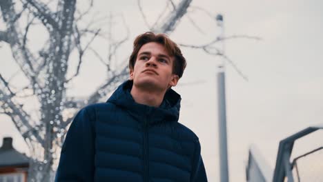 Slow-motion-shot-of-young-man-wearing-a-jacket-and-walking-down-the-stairs-on-a-winter-day