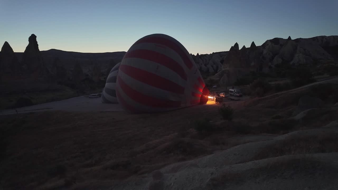 Heating hot air balloon before scenic sunrise flight in Cappadocia, Turkey