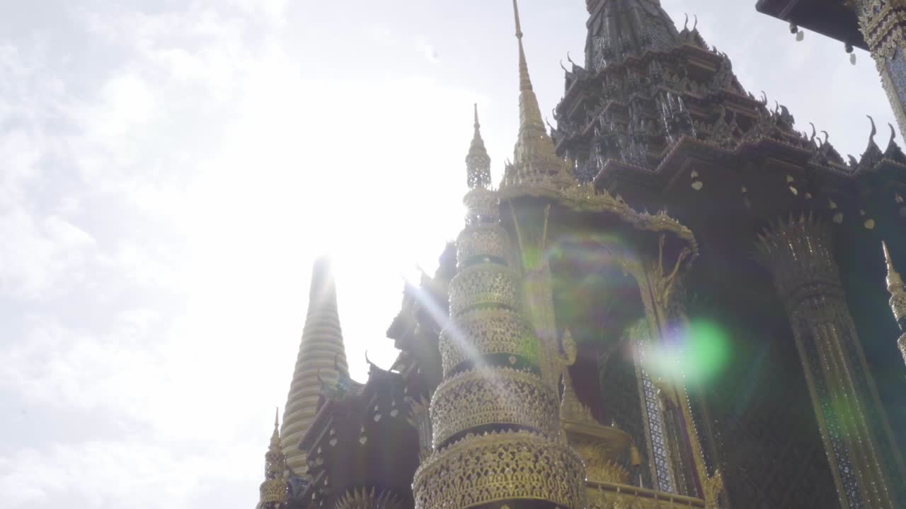 Sotto il tetto del Mondop a Wat Phra Kaew, con la luce del sole che filtra, Bangkok, Thailandia.