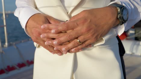 Husband and wife hold each other hands while standing in front of the catamaran sail boat