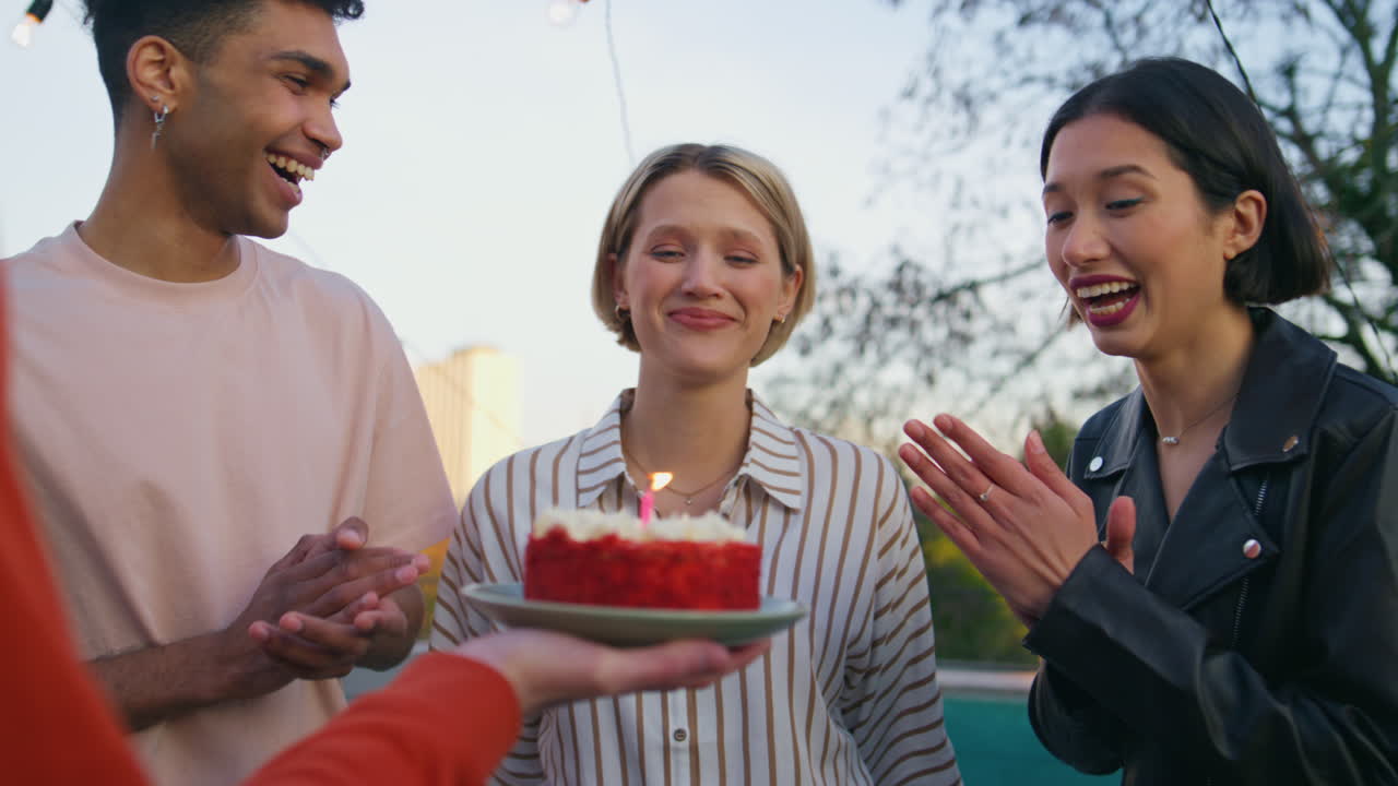 파티오 클로즈업에서 생일 케이크를 축하하는 행복한 사람들. 친구들이  놀랐습니다.