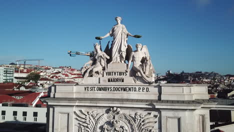 lisbon,rua agusta arc's top part statue's drone footage sliding from left towards right side on a beautiful sunny day with blue skies and white clouds