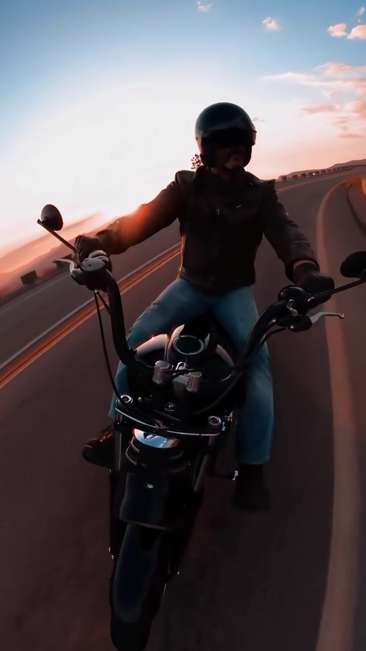 Motociclista che percorre una strada di montagna panoramica al tramonto