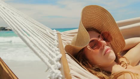 side view of caucasian woman relaxing in a hammock at beach 4k