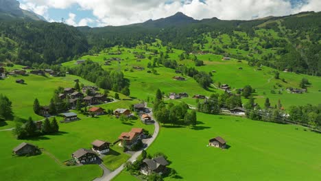 Aerial-view-over-the-summer-country-side-and-Eiger-express-in-Grindelwald,-Switzerland