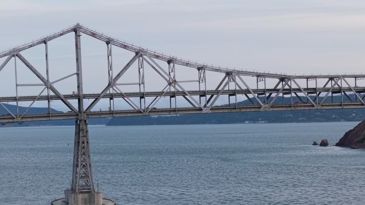 Close-up aerial footage follows the length of the Richmond–San Rafael Bridge, highlighting the flow of vehicles and the peaceful water beneath.