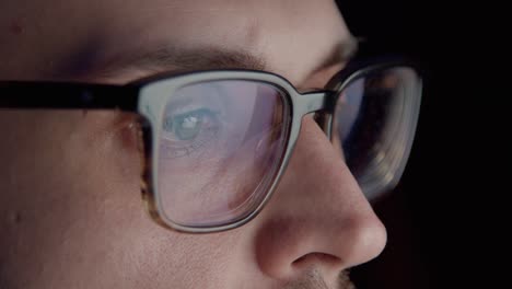 man trader in eyeglasses focused on stock market graphs