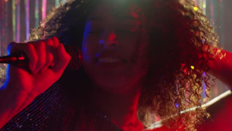 Young-Woman-With-Microphone-Singing-At-Karaoke-Nightclub-Bar-Or-Disco-With-Sparkling-Lights-In-Background-7