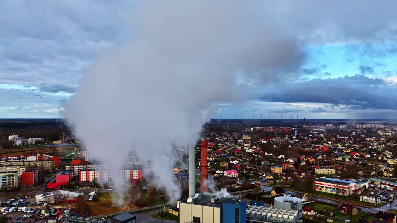 Luftfoto af kraftværkets røg, der driver mod vindmøller, gammel og vedvarende energi side om side, flyv igennem