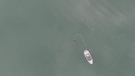 Low-altitude-birds-eye-view-of-water-skier-preparing-to-ski